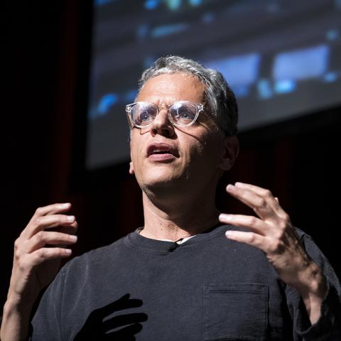 Professor Gil Weinberg gesturing hands while giving a presentation.