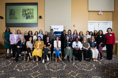 Group of 26 women posing in front of wall