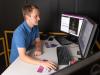 Pawel Golyski uses a computer to operate the CAREN system during an experiment.  